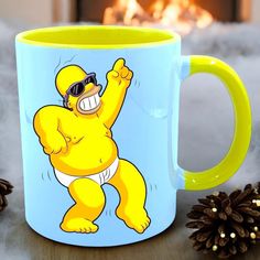 a mug with a cartoon character on it next to pine cones and a fire place