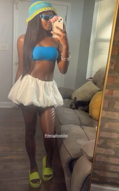 a woman taking a selfie in front of a mirror wearing a blue top and white skirt