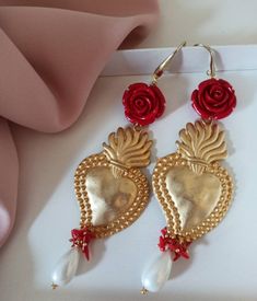 Extra long earrings made of: - Zama Brass Sacred Heart (47 mm x 370mm); - Smooth Mallorca Pearl drops (18 mm x 10 mm), white color; - Resin Roses; red color; - Bamboo Coral chips, red color; - Brass open hooks. Lenght : 12 cm / 4,72 inches * SHIPPING * Your order will be shipped within 1-3 business days from your purchase. You can choose between 2 shipping methods: STANDARD MAIL (NOT TRACEABLE) It is a cheap and fast shipping method, but NOT TRACEABLE. Chapeau Atelier is not responsible for any Extra Long Earrings, Color Resin, Roses Red, Bamboo Coral, Baroque Fashion, Lovely Shop, Gold Price, Sacred Heart, Pearl Drop