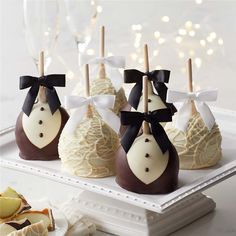 chocolate covered candies with black bows and white icing are on a platter