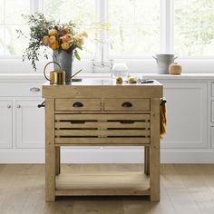 a kitchen with white cabinets and an island made out of wooden planks in the center