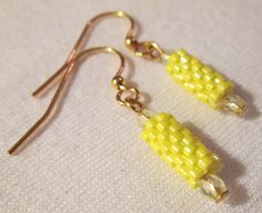 the earrings are yellow and have tiny beads