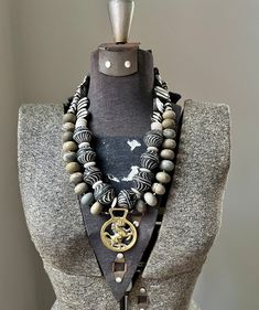 This big chunky necklace has a rare antique horse brass piece from the late 1800's as the main pendant at the bottom.  The strands are composed of big chunky grey jasper that each have a unique light and dark color.  The top strand has handmade African trade clay beads with African batik bone beads finishing off the ends.  White and black Tibetan agate finishes off the end of the other strand.   Connects in the back a gold plated hook and 2 1/2 in. extension chain. Please message me before order Black Gemstone Necklace, Necklace African, Horse Necklace, Necklace Chunky, Necklace Statement, Gemstone Necklace, White Black, Statement Necklace, Necklaces