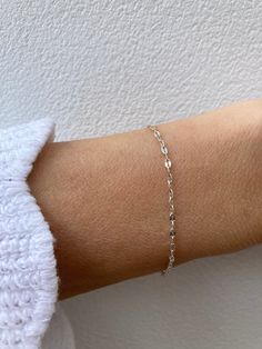 This super sparkly bracelet looks great stacked with other dainty bracelets! D E T A I L S  *925 sterling silver sequin chain measuring 1.8mm wide *A tiny sterling silver cross hangs from the end. *Hallmarked spring ring clasp.  S I Z I N G *  H E L P Choose the length from the drop down menu. Use the length guide as a reference. C A R E * T I P This is a dainty bracelet so please treat it with care. To maintain it in great condition avoid contact with water, perfume and harsh chemicals.Also remove when exercising, sleeping and doing housework in case it snags. Sterling silver can tarnish over time especially in humid conditions so always store in a dry place and if necessary clean with a jewellery cloth. P A C K A G I N G All our products are gift ready. T E R M S* O F* S A L E S & F A Q Sterling Silver Bracelet With Delicate Chain For Everyday, Everyday Sterling Silver Bracelet With Delicate Chain, Delicate Chain Sterling Silver Bracelet For Everyday, Everyday Silver Paperclip Bracelet With Delicate Chain, Adjustable Dainty Sterling Silver Paperclip Bracelet, Silver Paperclip Bracelet With Delicate Adjustable Chain, Silver Adjustable Paperclip Bracelet With Delicate Chain, Minimalist Silver Paperclip Bracelet With Delicate Chain, Adjustable Silver Paperclip Bracelet With Delicate Chain