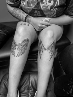 a person with tattoos sitting on a couch