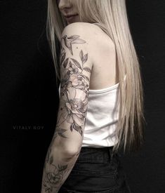 a woman with long blonde hair and flowers on her arm