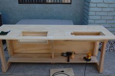 the workbench is being built with tools on it's sides and in front of a building