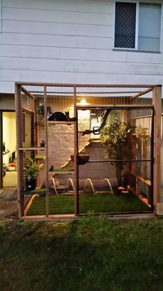 an outside view of a house with the back door open and grass in front of it