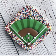 a cake shaped like a baseball field with sprinkles on it's sides