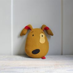 a brown stuffed animal with red ears and nose