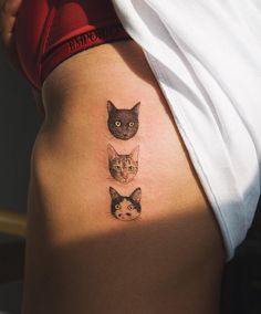 three cats tattoo on the back of a woman's lower body, with one cat looking at the camera