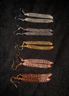 five different types of chainmails on a black cloth with gold and silver chains