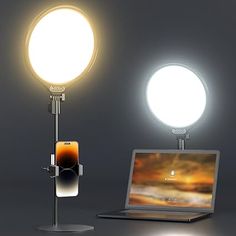 an open laptop computer sitting on top of a desk next to a light and lamp