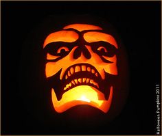 a carved pumpkin with an evil face on it's face and mouth is lit up in the dark