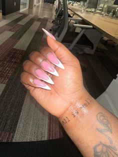 a woman's hand with pink and white stiled nails holding up her arm