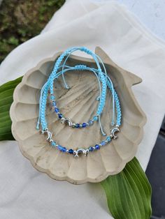 Featuring a light blue woven adjustable anklet or bracelet with small silver plated dolphins and genuine Czech crystals in assorted blue. Silver Beaded Braided Bracelets For The Beach, Blue Bracelet Anklets For Beach, Summer Ocean-inspired Beaded Anklets, Ocean-inspired Strand Anklets As A Gift, Ocean-inspired Blue Beaded Anklet, Blue Ocean-inspired Anklets For Summer, Dolphin Bracelet, Dolphin Lover, Dolphin Jewelry