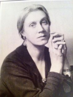 an old black and white photo of a woman holding her hand up to her face