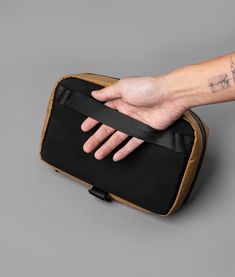 a person's hand on top of a black and tan case with cross tattoos