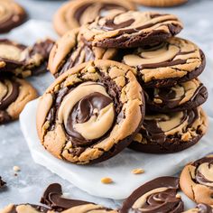 chocolate peanut butter swirl cookies on a white platter with more cookies in the background