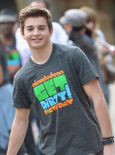 a young man walking down the street in front of a group of people wearing t - shirts that say get dirty friday