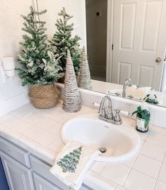 a bathroom sink sitting under a mirror next to a counter top with christmas trees on it