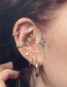 a close up of a person with ear piercings on their ears and behind the ear