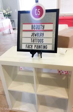 a sign that says beauty, jewelry, tattoos, face painting on top of a bookcase