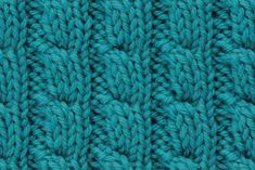 close up view of the texture of a knitted fabric in teal green color