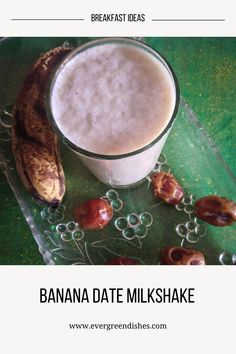 a banana sitting next to a glass filled with milk and nuts on top of a green table