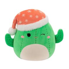 a green stuffed animal with a santa hat on it's head and eyes closed