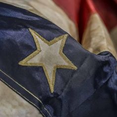 a gold star is on the back of a blue and white jacket with red linings