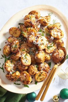 a white plate topped with fried potatoes covered in parmesan cheese