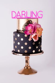 a polka dot cake with pink flowers and the word darling on top is shown