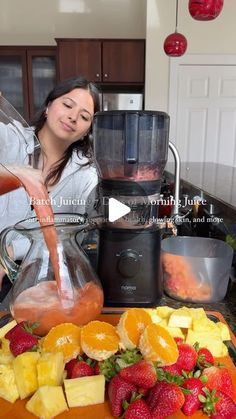 a woman is pouring fruit into a blender