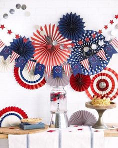 an american themed party with red, white and blue paper fan decorations on the wall