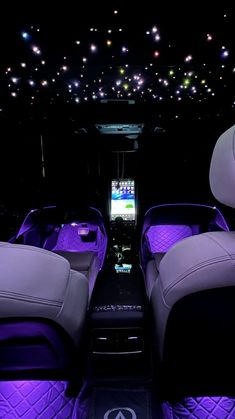 the interior of a vehicle with purple leather seats and lights in the ceiling above it