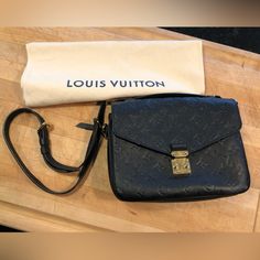 Base Length: 9.75 In Height: 7 In Width: 2.75 In Drop: 1 In Drop: 20.5 In This Is An Authentic Louis Vuitton Empreinte Pochette Metis In Black. This Stylish Shoulder Bag Is Finely Crafted Of Black Calfskin Leather Embossed With The Louis Vuitton Monogram. The Handbag Features A Black Leather Top Handle, An Adjustable Leather Shoulder Strap, And Polished Gold-Toned Hardware. The Front Flap Opens With An S-Lock To A Partitioned Gray Striped Fabric Interior. Pochette Metis Black, Black Leather Top, Pochette Metis, Louis Vuitton Empreinte, Bags Louis Vuitton, Stylish Shoulder Bag, Black Purse, Striped Fabric, Black Purses