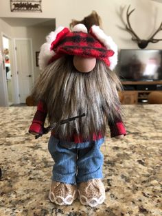 the doll is wearing a red and black plaid hat