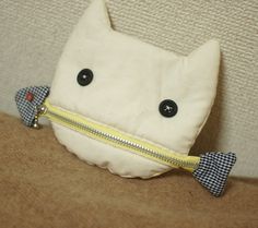 a white stuffed animal with a yellow zipper