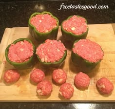 green peppers filled with meat sitting on top of a wooden cutting board