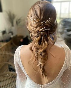 the back of a woman's head with long hair and flowers in her hair