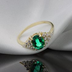 "Handmade by an inspired jewelry artist team with decades of experience in the craft of jewelry making. Each gemstone, each diamond is carefully picked. Using only the finest raw materials and the highest industry standard in manufacturing, design and finish. Emerald oval gemstone and diamonds 14K gold ring. showcasing a beautiful oval cut Colombian Emerald. Engulfed on both sides with white diamond full of fire and sparkle. Gemstone info: ------------------------------ √ Oval cut, prong set. Co Exquisite Oval Emerald Ring With Diamond Accents, Oval Cubic Zirconia Emerald Ring In Fine Jewelry Style, Oval Birthstone Ring With Diamond Accents, Exquisite Oval Emerald Ring With Accent Stones, Oval Diamond Ring For May Birthstone, Oval Crystal Ring In 14k Gold With Prong Setting, Exquisite 14k Gold Oval Rings, Yellow Gold Oval Diamond Crystal Ring, Oval Emerald Ring With Diamond Accents For Gift