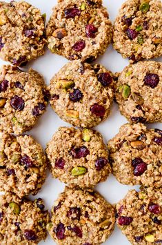 a white plate topped with cookies covered in nuts and cranberry toppings on top of each other