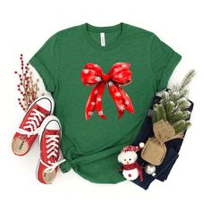 Looking for a cute tee for your kids? We have the perfect Coquette Christmas Snowflake Bow graphic tee addition to their closet! Also available in toddler tees. Cute Red Holiday Tops, Cute Red Winter T-shirt, Cute Red T-shirt For Winter, Cute Winter T-shirt For Gift, Cute Christmas Festive Tops, Cute Festive Christmas Tops, Cute Holiday T-shirt With Crew Neck, Cute Holiday T-shirt For Winter, Cute Winter Holiday T-shirt