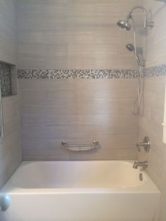 a white bath tub sitting inside of a bathroom next to a shower head and faucet