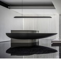 a black and white photo of a modern dining room with an oval table in the center