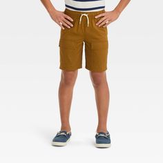 Prepare your young explorer for an adventurous day with these Relaxed 'At the Knee' Pull-On Cargo Shorts from Cat & Jack™. Crafted from 100% cotton blend with comfy lining, these mid-rise shorts offer comfortable all-day wear. The solid-color finish adds a touch of flair to their outfit plus the flexible waistband with a front drawstring ensures a secure fit. Complete with cargo pockets on the legs as well as side and back pockets, these shorts combine stylish design with functional flair. Cat & Casual Short Bottoms For Summer Adventures, Casual Bottoms With Pockets For Adventure, Casual Adventure Bottoms With Cargo Pockets, Casual Bottoms With Cargo Pockets For Adventure, Casual Brown School Bottoms, Casual Brown Bottoms For School, Playful School Shorts With Pockets, Brown Shorts For Outdoor Activities In Summer, Brown Shorts For Outdoor Summer Activities