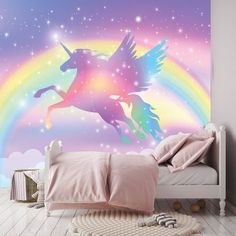 a bedroom with a unicorn wall mural in the background and a rainbow painted on the wall