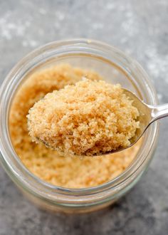 a spoon with some food in it on top of a glass jar filled with something