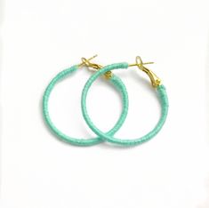 "A pair of mint green hoops, wrapped by hand in the UK. These earrings are cheery, bright and perfect for your summer vacation!  The hoop itself has been wrapped with quality embroidery thread in a shade of mint green, giving them a huge pop of colour.  A nice change from the usual gold and silver hoops.  Measuring approximately 1.25\" (3cm)   in diameter, these hoops are relatively small. They are also very lightweight and are comfortable to wear all day long.  The ear post has a lever mechanis Mint Green Earrings, Thread Earrings, Green Earrings, So Much Love, Uk Fashion, Jewelry Earrings Hoops, Silver Hoops, Embroidery Thread, Pretty Things